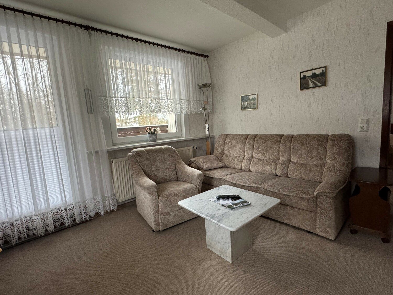 Wohnzimmer mit Sofa, Sessel und Marmortisch
